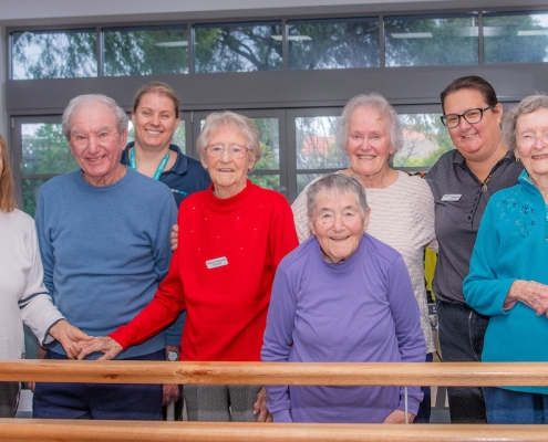 Happy Capecare clients and Allied Health staff pose for a photo in the gym