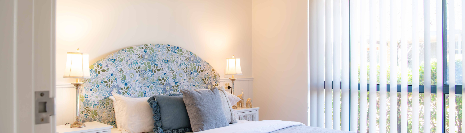 Pretty blue and cream bedroom with fabric bedhead and soft furnishings