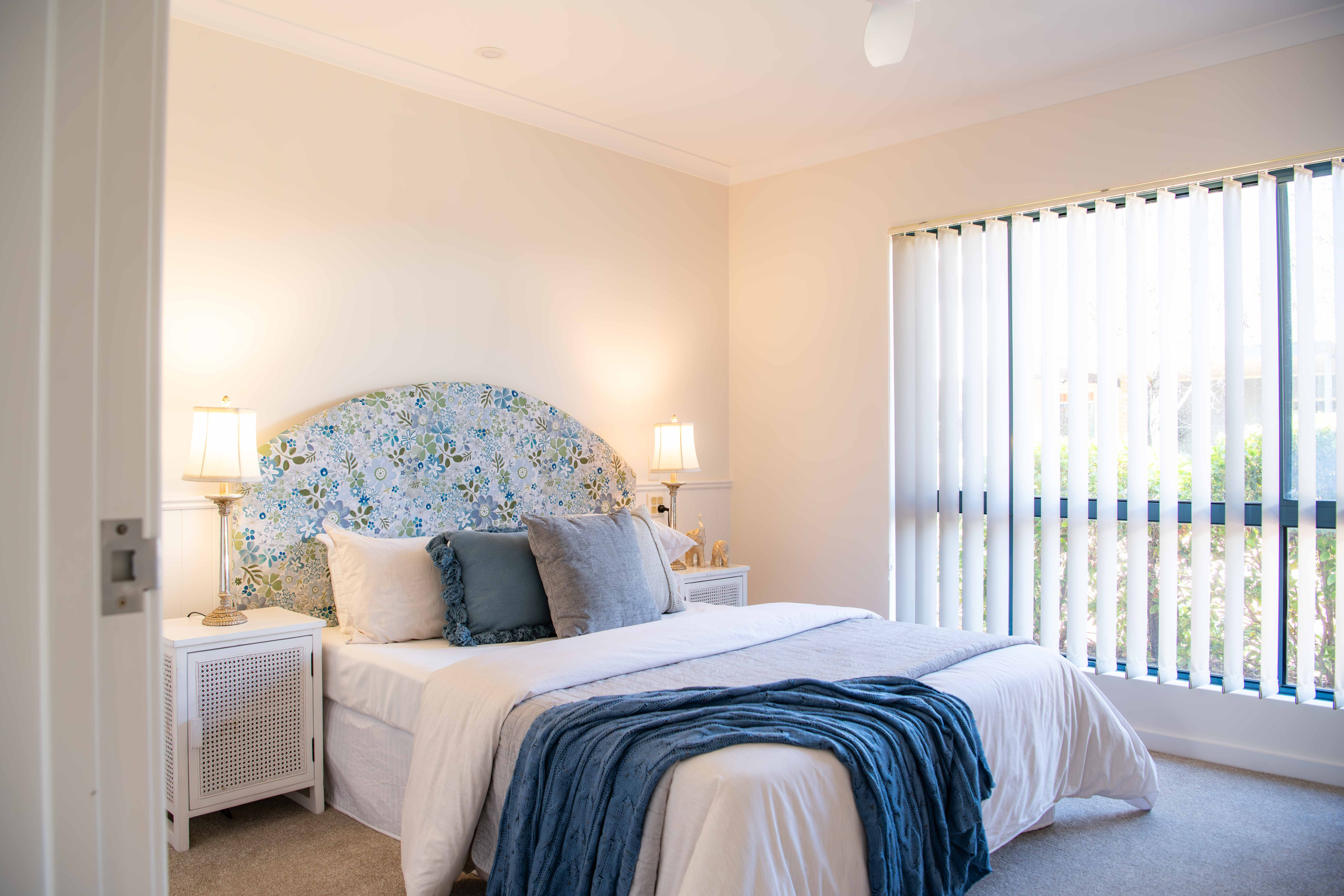 Pretty blue and cream bedroom with fabric bedhead and soft furnishings