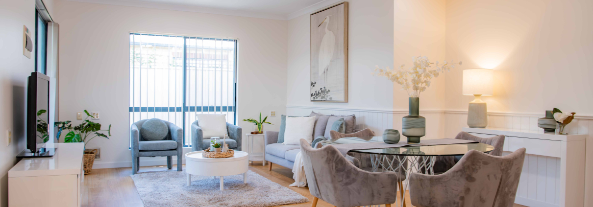 interior of a refurbushed retirement unit showing dining table and lounge with a light filled window