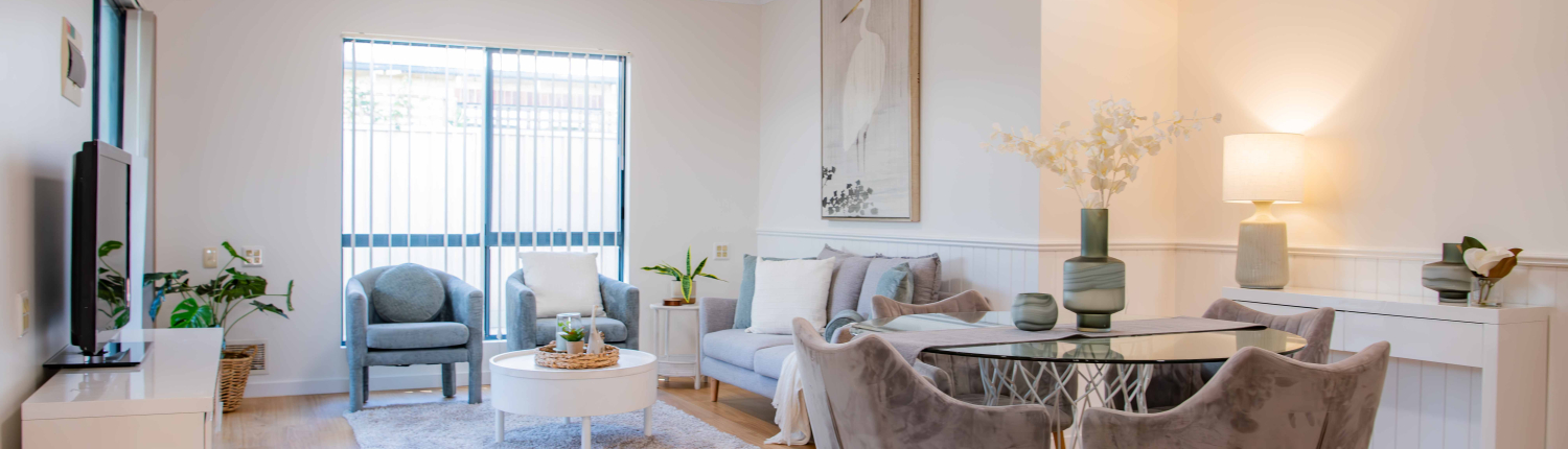 interior of a refurbushed retirement unit showing dining table and lounge with a light filled window