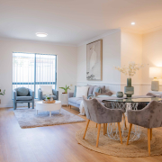 interior of a refurbushed retirement unit showing dining table and lounge with a light filled window