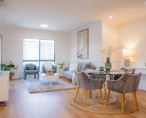 interior of a refurbushed retirement unit showing dining table and lounge with a light filled window