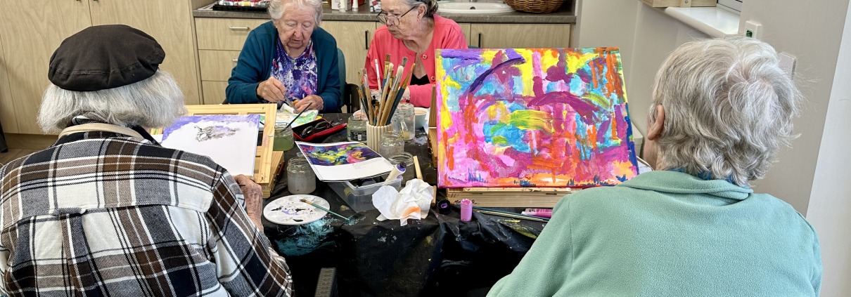 four older ladies working on painting in a group