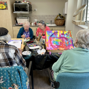 four older ladies working on painting in a group