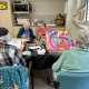 four older ladies working on painting in a group