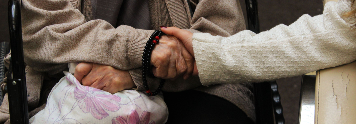 two older people holding hands